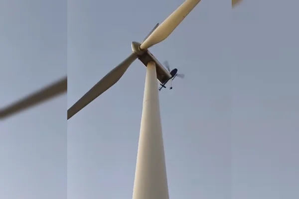 Imagem colorida, helicóptero de resgate ao lado de usina eólica - Metrópoles