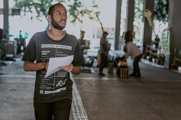 Com currículo impresso na camisa, jovem desempregado procura trabalho