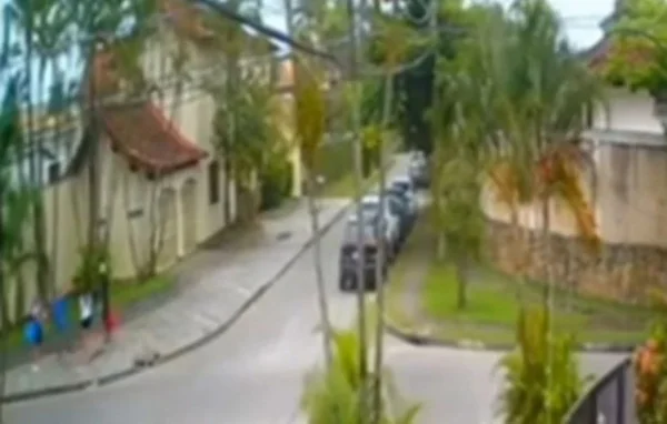 Imagem colorida de câmera de segurança mostra dois bandidos roubando a família de um PM no Guarujá; criminosos apontaram uma arma para uma bebê de um ano - Metrópoles