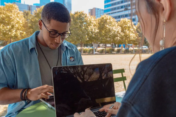 menino e menina mexendo no computador em parque