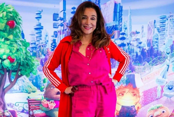 Foto colorida de Marisa Orth com as mãos nos bolsos e conjunto vermelho - Metrópoles