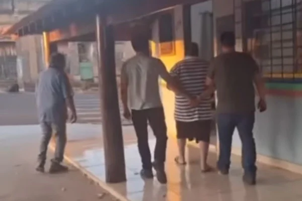 Imagem colorida do momento em que o criminoso foi encaminhado à delegacia de polícia. Metrópoles