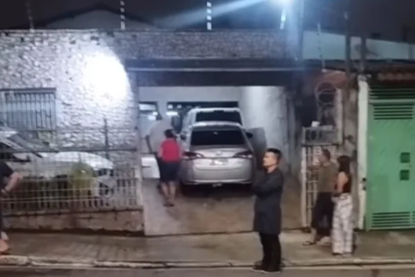 Imagem colorida de pessoas em frente à residência após assalto