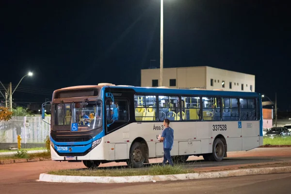 Ônibus azul e branco com janela quebrada