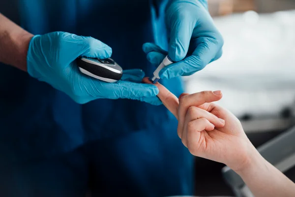 Médico realizando um exame de glicemia em um paciente em uma clínica. Diabetes. Metrópoles