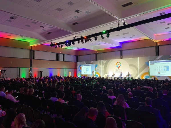 Fotografia colorida mostrando auditório lotado com pessoas no palco - Metrópoles
