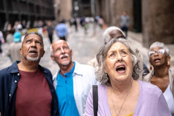 Foto colorida de pessoas assustadas olhando para cima - fim do mundo - Metrópoles.