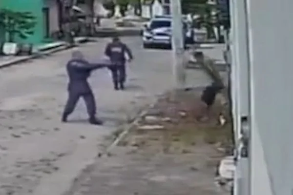 imagem de câmera de segurançamostra policial segurando arma e homem encostado em parede no Espírito Santo - Metrópoles