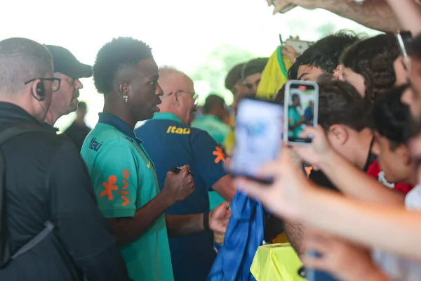 Foto colorida de Vini Jr dando autografo - Metrópoles
