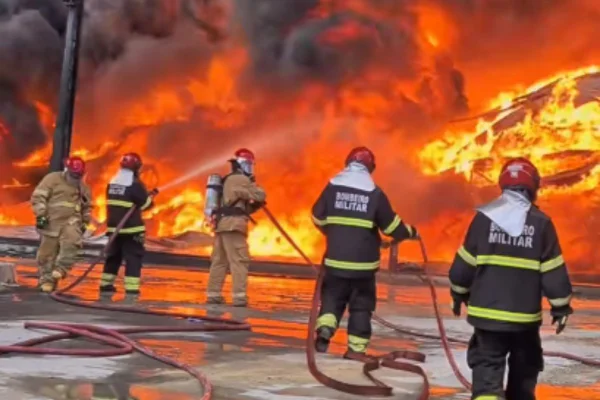 Foto colorida de bombeiros combatendo chamas do incêndio de grande proporção em fábricas que já dura mais de 15 horas - Metrópoles