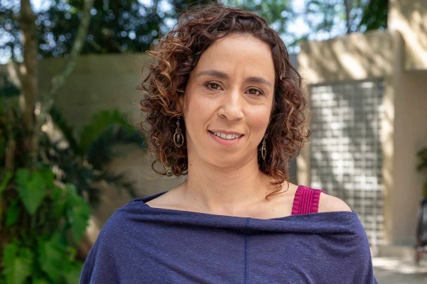 Mulher de blusa azul e cabelo encaracolado - Metrópoles