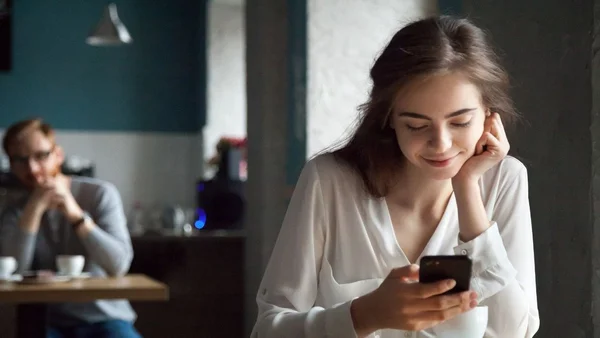 Mulher mexendo no celular e sorrindo