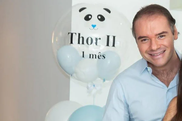 Thor Batista usando blusa azul e sorrindo - Metrópoles
