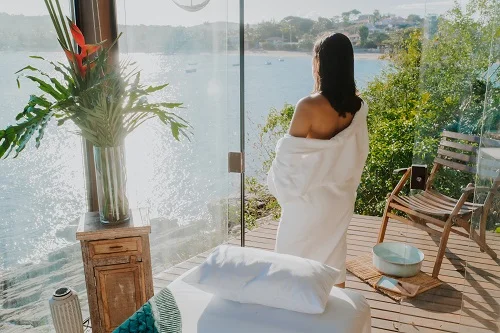 mulher em quarto de spa em frente ao mar