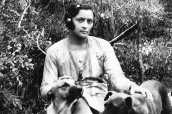 Imagem em preto e branco de Maria Bonita com cachorros - Metrópoles