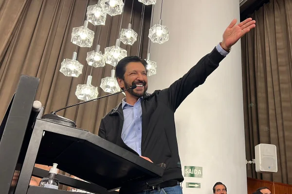 Imagem colorida mostra Ricardo Nunes, homem branco, de cabelo e barba pretos, no púlpito do salão nobre da Câmara, sorrindo - Metrópoles