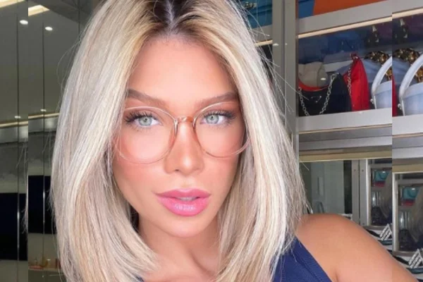 Fotografia colorida de Flavia Pavanelli posando para selfie de óculos
