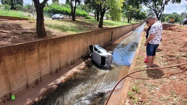 Imagem colorida de carro em córrego - Metrópoles
