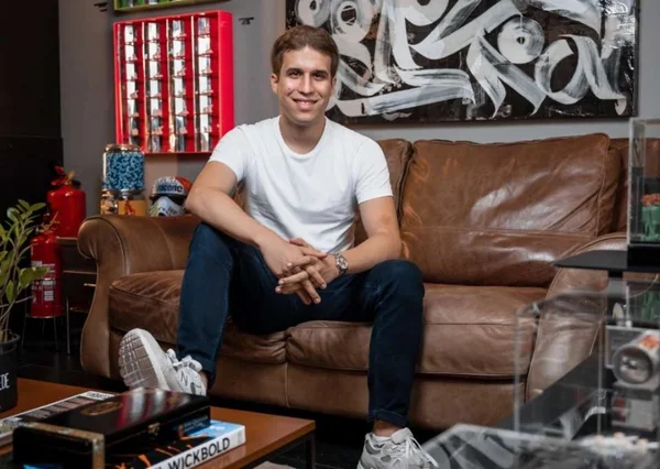 Na foto, João Bogado está sentado e sorrindo - Metrópoles