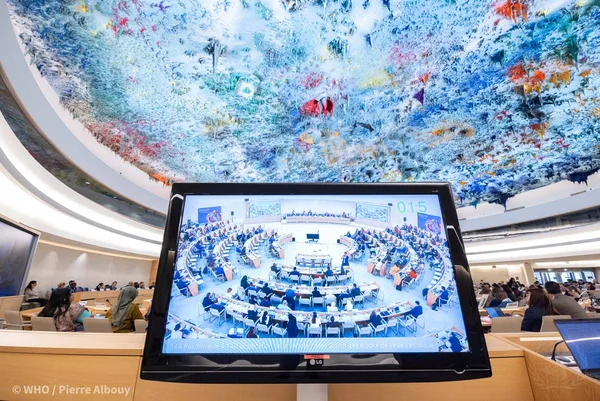 Imagem colorida mostra tela com o plenário da Assembleia Geral da OMS - Metrópoles