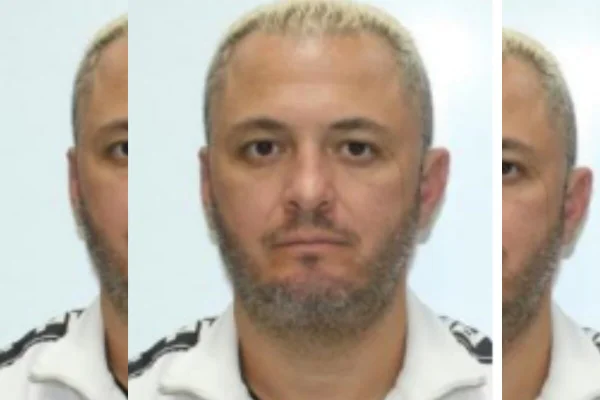 Homem branco com barba grisalha, poucos cabelos ralos e semblante sério, usando camiseta polo branca - Metrópoles