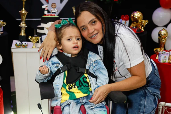 Imagem colorida de criança e mulher branca se abraçando - Metrópoles