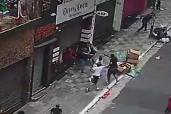 Imagem colorida de câmera de segurança mostra homem dando tiro na ex-mulher, uma empresária da rua 25 de Março, no centro de São Paulo - Metrópoles