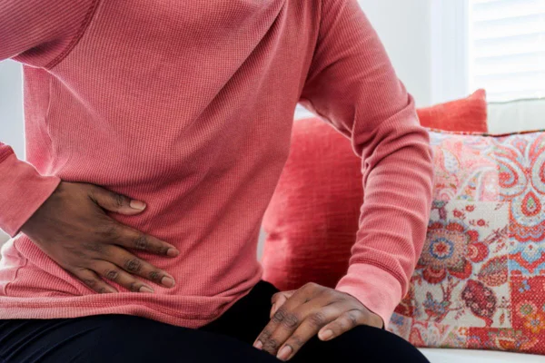 Imagem colorida de mulher com a mão na barriga