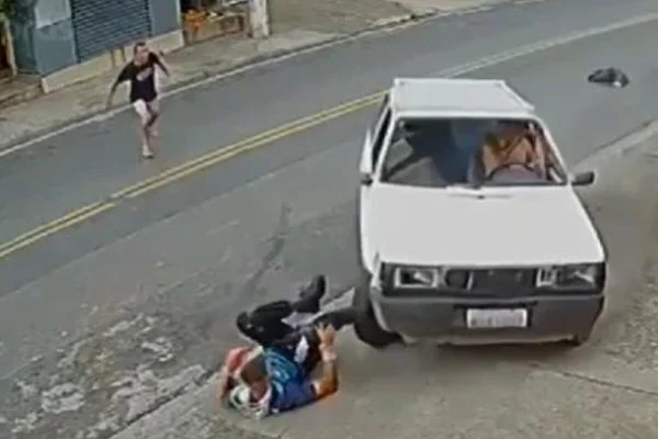 Carro branco se aproxima de homem caído em calçada - Metrópoles