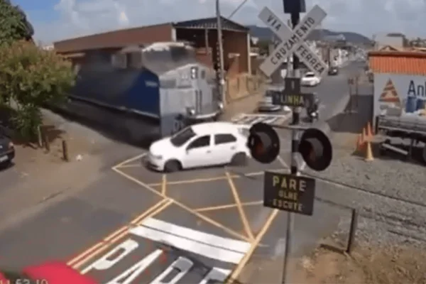 Imagem colorida de trem atingindo carro em ferrovia - Metrópoles