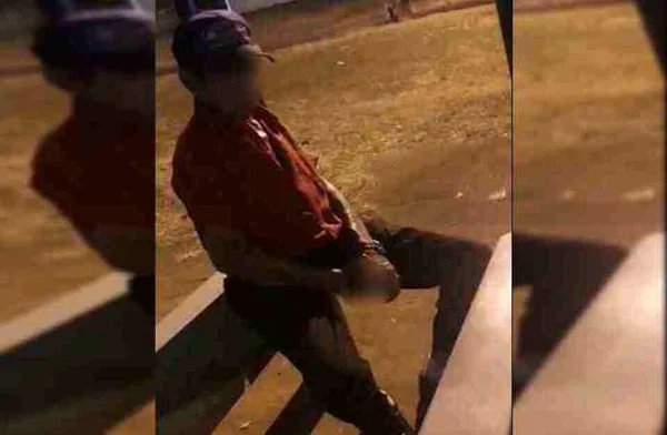 Homem sentando de boné e blusa vermelha