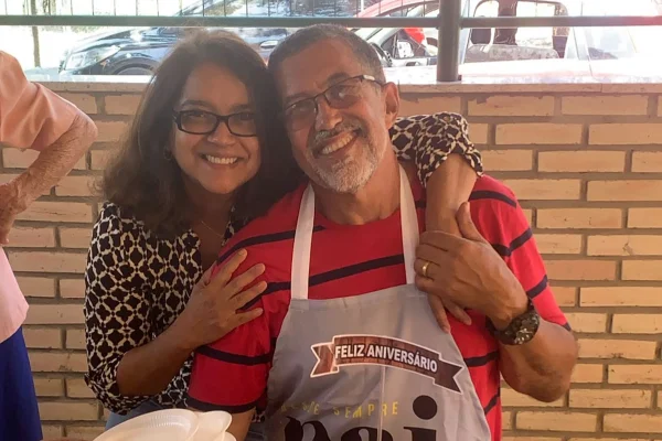 Foto colorida de casal se abraçando, sorrindo para foto - Metrópoles