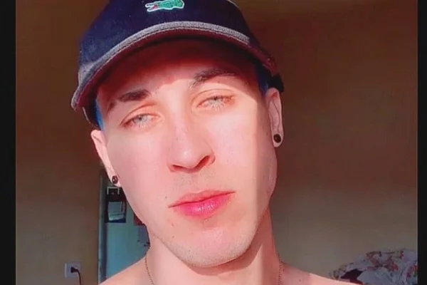 Jovem branco de boné preto e olhos azuis com luz do sol no rosto - Metrópoles