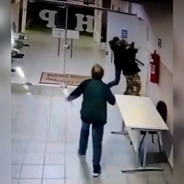 Momento em que diretora de escola é agredida e pessoa da mata-leão nela, em corredor. A agressão ocorreu em Itararé, São Paulo - Metrópoles