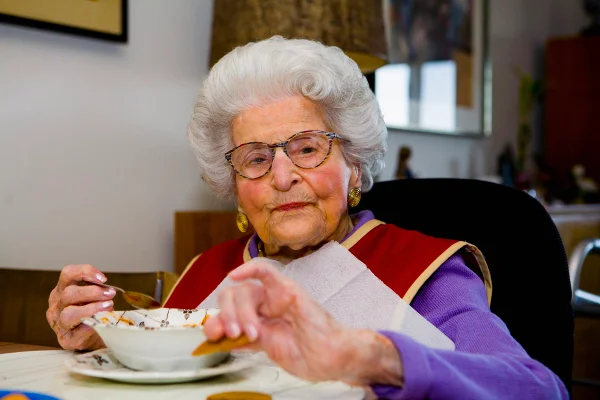 Foto colorida de mulher idosa comendo - Metrópoles