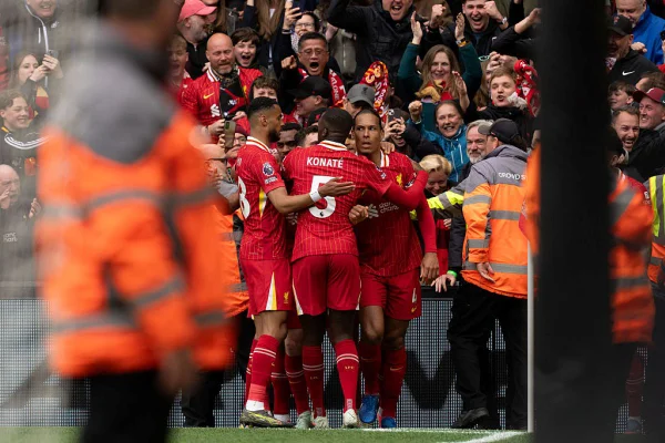 Imagem mostra jogadores de futebol abraçados comemorando gol - Metrópoles