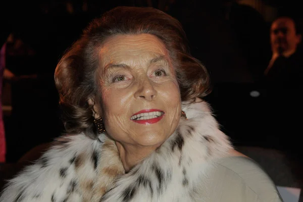 Foto colorida de mulher idosa, com cachecol com pelos. Ela usa batom vermelho - Metrópoles