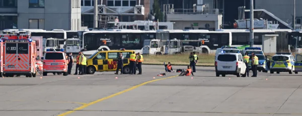 Foto colorida de manifestantes deitados na pista do aeroporto - etrópoles