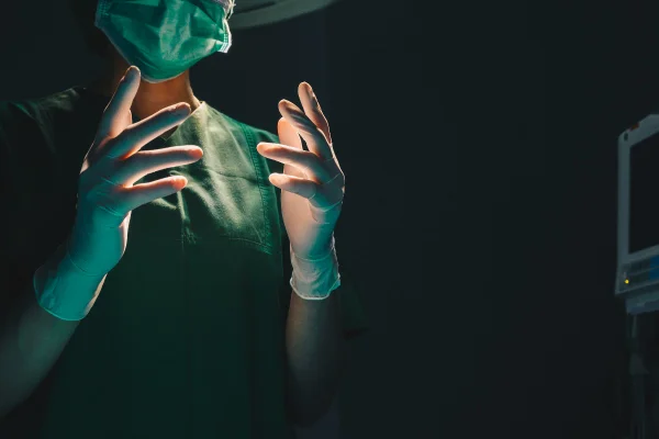 Foto colorida mostra uma médica de luvas