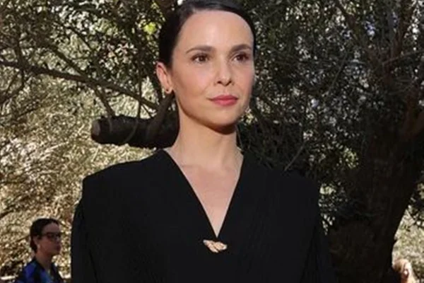 Débora Falabella posa, séria, de look preto e cabelos presos - Metrópoles
