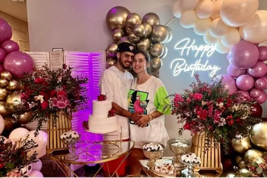 Virgínia e Zé Felipe posam em frente a mesa de doces e bolo do aniversário de Virgínia