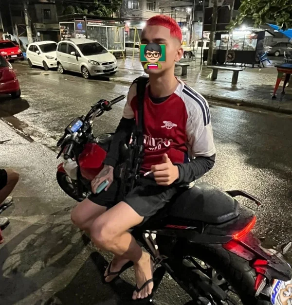 Jovem com camisa do Arsenal sentado em moto