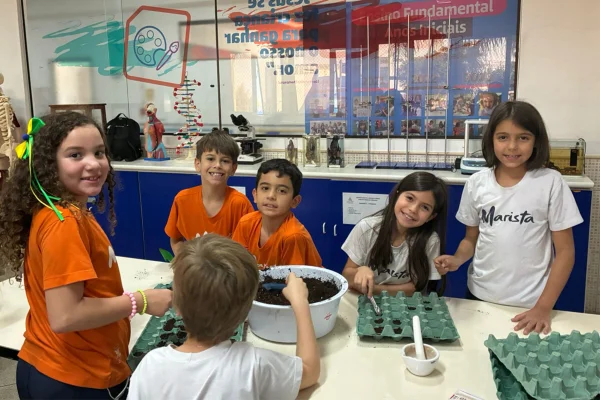 Fotografia colorida de estudantes durante atividade em sala-Metrópoles