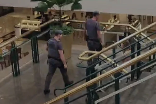 Captura de tela colorida que mostra dois policiais militares atendendo a ocorrência de roubo no shopping Iguatemi, em Campinas, no interior de SP. - Metrópoles