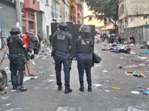 Imagem mostra pessoas fardadas em meio à rua - Metrópoles