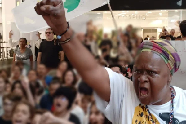 Imagem colorida mostra mulher negra em protesto no Shopping Pátio Higienópolis contra racismo cometido por seguranças - Metrópoles