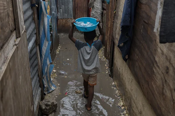 Imagem colorida de pessoas vivendo em áreas alagadas sob circunstâncias difíceis em Porto Príncipe, Haiti, em 29 de outubro de 2025