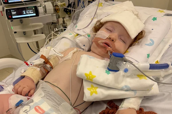 Foto colorida de criança em ambiente hospitalar conectada a tubos - Metrópoles