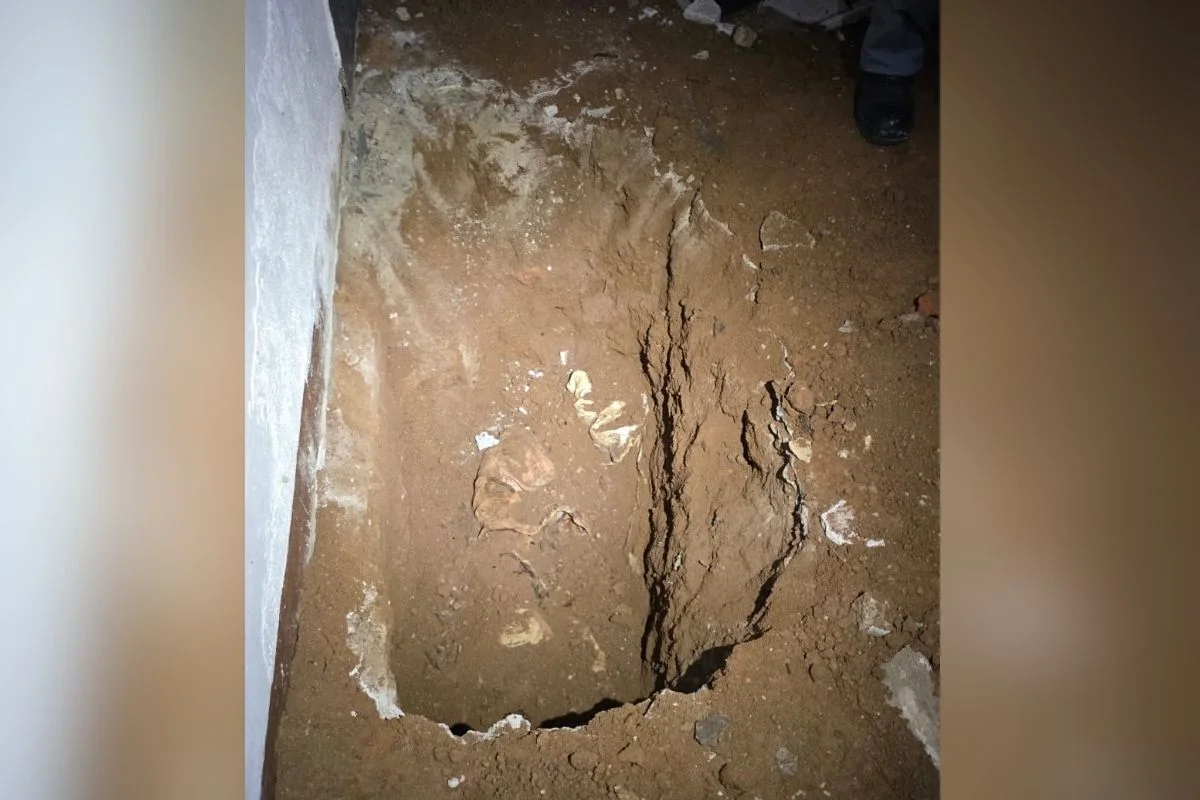 Foto colorida de cova em que mulher foi enterrada dentro de quarto no bairro Itaquera, zona leste de São Paulo.