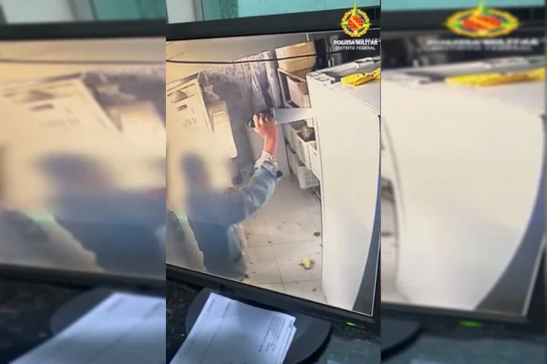 Frame de vídeo tela de computador mostra homem enfiando faca de cozinha em armário